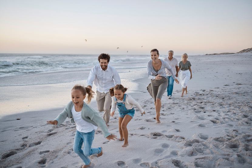 En familj som springer glatt längs stranden